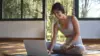 Frau im Yogaoutfit vor ihrem Laptop