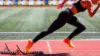 Läuferin startet aus Startblock auf einer Tartanbahn